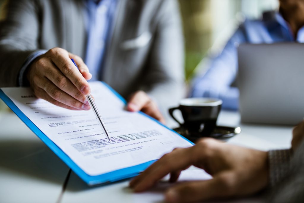 Close up of businessman highlighting part of a contract